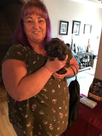 a woman holding a puppy in a living room