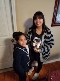 a woman and a girl standing in front of a door