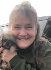 a woman holding a small dog in her arms