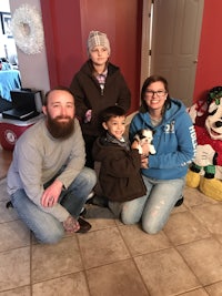 a family posing with stuffed animals in a living room